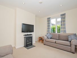 A living room with a television and a fireplace at Hillcroft Bungalow Daymer Bay