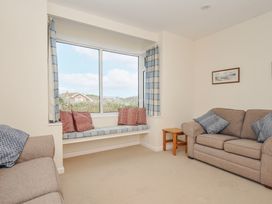 A living room with sofas and a window at Hillcroft Bungalow Daymer Bay
