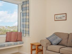 A living room featuring a window with curtains and seating at Hillcroft Bungalow Daymer Bay