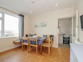 A dining room with a table and chairs at Hillcroft Bungalow Daymer Bay
