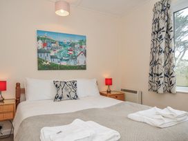 A bedroom with a double bed and wall art at Hillcroft Bungalow Daymer Bay