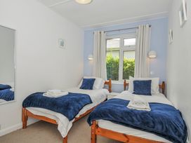 A bedroom with two beds and a window at Hillcroft Bungalow Daymer Bay