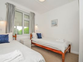 A bedroom with two beds and a window at Hillcroft Bungalow Daymer Bay
