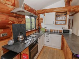 A kitchen with a gas stove and sink at Cedar Cabin at Salford Court Farm Fishing Cabins near Clifton Upon Teme