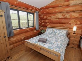 A bedroom with a bed and wardrobe at Cedar Cabin at Salford Court Farm Fishing Cabins near Clifton Upon Teme