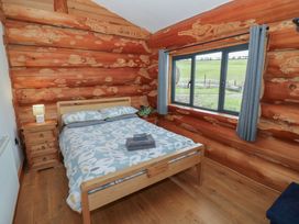 A bedroom with a bed and a window at Cedar Cabin at Salford Court Farm Fishing Cabins Near Clifton Upon Teme