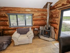 A living room with a wood stove and sofa at Douglas Cabin at Salford Court Farm Fishing Cabins near Clifton Upon Teme