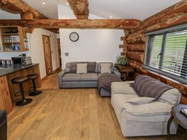 A living room with sofas and a kitchen counter at Douglas Cabin at Salford Court Farm Fishing Cabins near Clifton Upon Teme