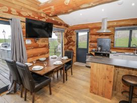 A kitchen with a dining table and chairs at Douglas Cabin at Salford Court Farm Fishing Cabins Near Clifton Upon Teme