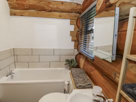 A bathroom with a bathtub, toilet, and sink at Douglas Cabin at Salford Court Farm Fishing Cabins near Clifton Upon Teme