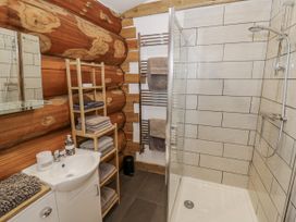 A bathroom with a shower and towels at Douglas Cabin at Salford Court Farm Fishing Cabins Near Clifton Upon Teme
