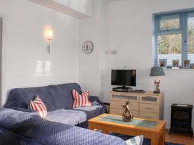 A living room with a television and sofa at Gilly's Cottage in Hope Cove