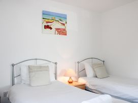 A bedroom with two beds and a lamp at Gilly's Cottage in Hope Cove