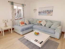 A living room with a sofa and table at Charlecote House in Saundersfoot