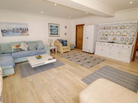 A living room with a sofa and coffee table at Charlecote House in Saundersfoot