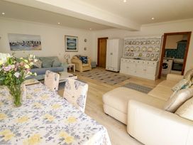 A living room with a table, chairs, and a sofa at Charlecote House in Saundersfoot