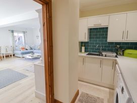 A kitchen with sink and cabinets at Charlecote House in Saundersfoot