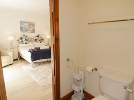 A bedroom with a bed and a bathroom with a toilet at Charlecote House in Saundersfoot