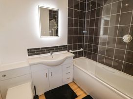 A bathroom with a bathtub, sink, and toilet at Charlecote House in Saundersfoot