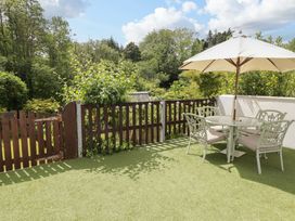 A garden with a table and chairs under an umbrella at Charlecote House in Saundersfoot