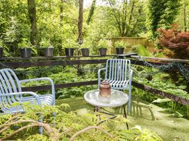 A garden with chairs, a table and potted plants at Charlecote House in Saundersfoot