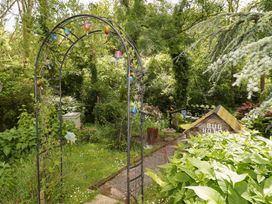 A garden with an arch and bug hotel at Charlecote House Saundersfoot