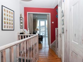 A hallway with a staircase and framed artworks at 13 Above Town in Dartmouth