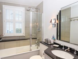 A bathroom with a bathtub, shower, and sink at 13 Above Town Dartmouth