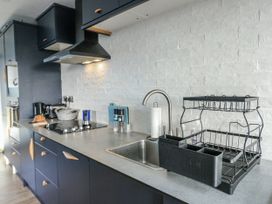 A kitchen with a sink and dish rack at 7 Bro Branwen Aberffraw near Rhosneigr