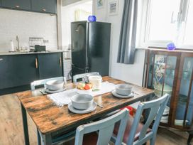 A kitchen with a dining table and chairs at 7 Bro Branwen near Rhosneigr