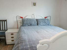 A bedroom with a bed and bedside lamp at 7 Bro Branwen near Rhosneigr