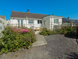 A house with garden flowers and a pathway at 7 Bro Branwen Aberffraw near Rhosneigr