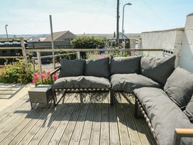 An outdoor seating area with cushions and a small table at 7 Bro Branwen Aberffraw near Rhosneigr