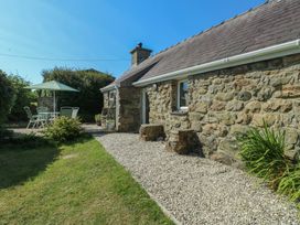 An outdoor area with a stone cottage and seating at Sunstone (Garreg Haul) Cilan near Abersoch
