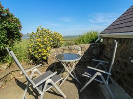 An outdoor space with chairs and a table at Sunstone (Garreg Haul) Cilan near Abersoch