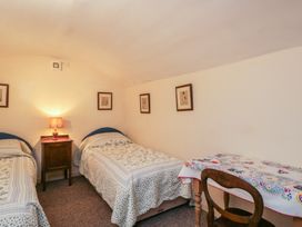 A bedroom with two beds and a table at Dollar Ward House Basement Cirencester