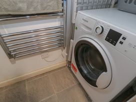 A laundry room with a washing machine and a towel rail at Dollar Ward House Basement Cirencester