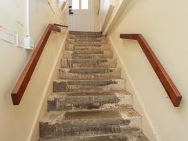A staircase with wooden handrails and a door at Dollar Ward House Basement Cirencester