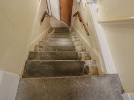 Stairs with a handrail leading to a door at Dollar Ward House Basement Cirencester