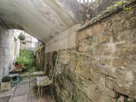 A garden area with stone walls and outdoor seating at Dollar Ward House Basement Cirencester
