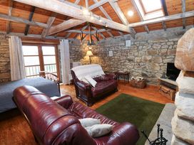 A living room with leather furniture and a television at The Granary in Rothbury