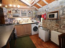 A kitchen with appliances and wooden cabinets at The Granary in Rothbury