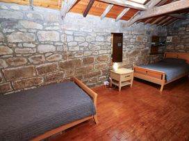 A bedroom with two beds and a bedside table at The Granary in Rothbury