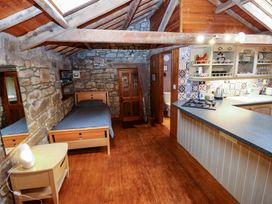 A living room with a bed and kitchen area at The Granary in Rothbury