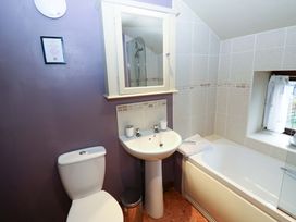 A bathroom with a toilet, sink, bathtub, and shower at The Granary in Rothbury