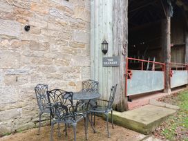 A table and chairs by a stone wall at The Granary in Rothbury