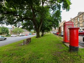 A park area with a telephone box and post box at The Granary in Rothbury
