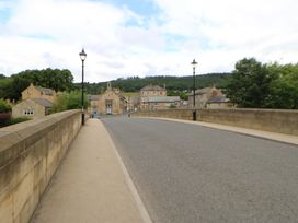 A street view with a bridge and buildings at The Granary in Rothbury