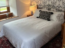 A bedroom with a bed and window at Swaledale Watch Garden Annexe Caldbeck
