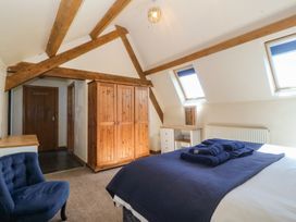 A bedroom featuring a bed, wardrobe and desk at Cefnbron in Llanaelhaearn near Trefor